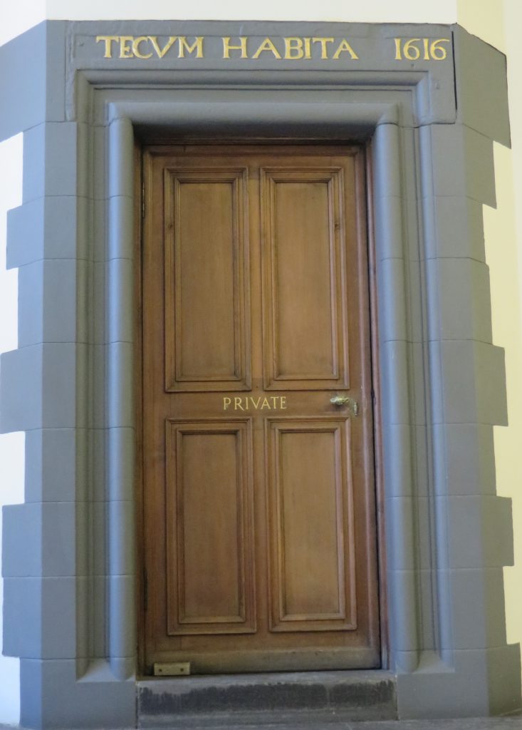 A door, above a seventeenth century motto in Latin: Tecum Habita.