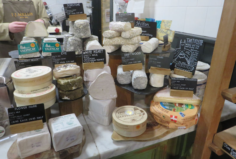 A marble counter with many soft cheeses