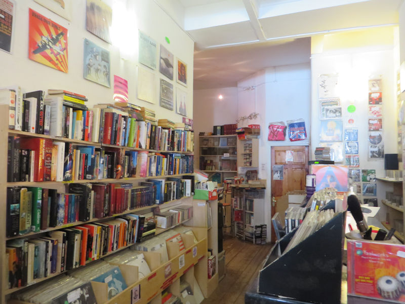 A shop interior with rows of books above rows of Vinyl records