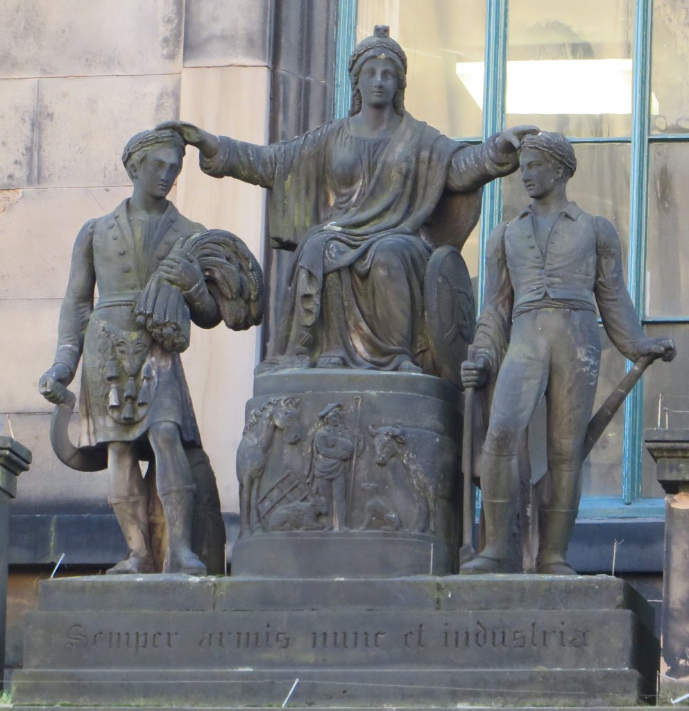 figure, seated upon a raised dais, is Caledonia, the female personification of Scotland. Her right hand rests upon a kilted Highland reaper carrying a sickle and a stoop of corn. Her left hand is placed upon a ploughboy.