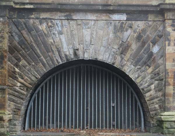 Entrance to a railway tunnel, now sealed of with barred metal gates.